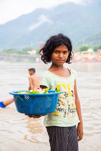 Portrait of young woman standing at ganga river