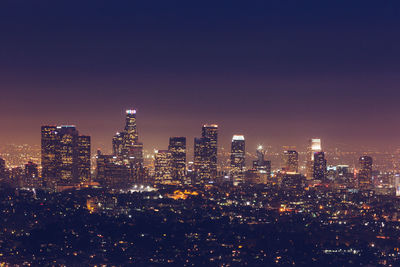 Illuminated cityscape against sky at night