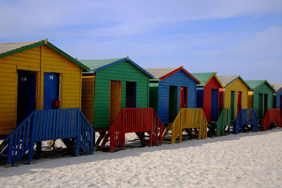 Row of houses on beach against sky