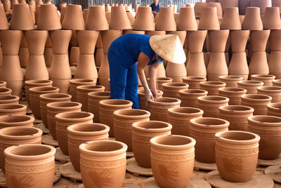 Side view of woman arranging potteries at market
