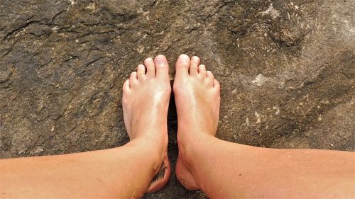 Low section of woman standing on rock