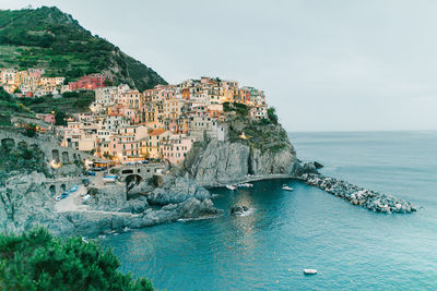 Scenic view of sea by buildings against sky