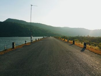 Road by trees against clear sky