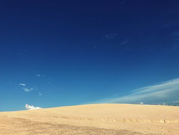 Scenic view of desert against blue sky