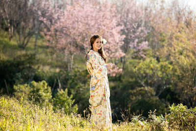 Woman standing by flower tree