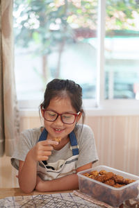 Smiling girl eating food at home