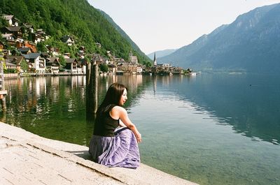 Rear view of woman standing by lake