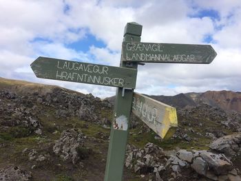 Low angle view of road sign against sky