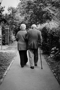 Rear view of people walking on footpath