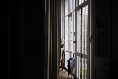 Man looking through window at home