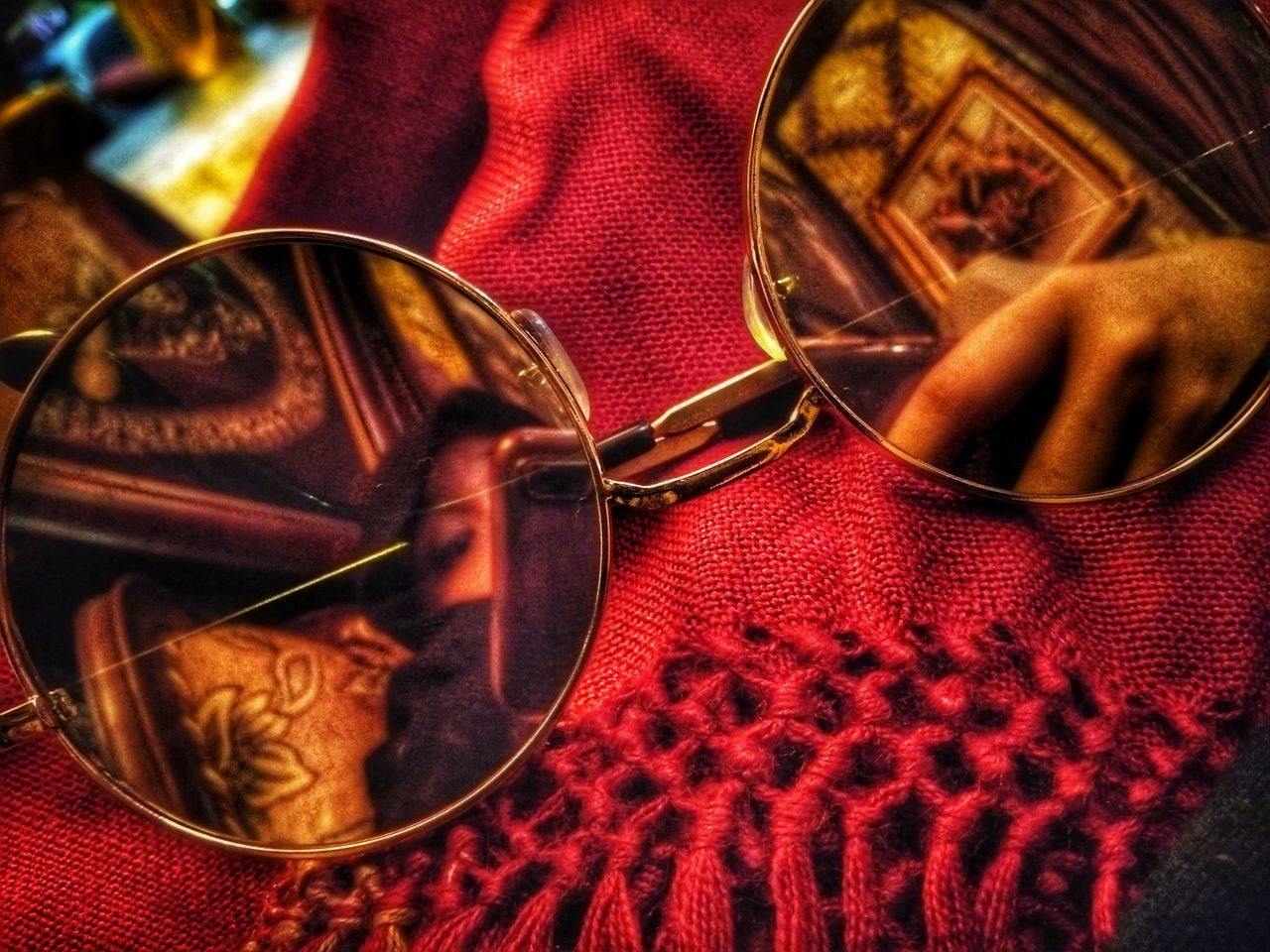 HIGH ANGLE VIEW OF SUNGLASSES AND WOMAN ON TABLE