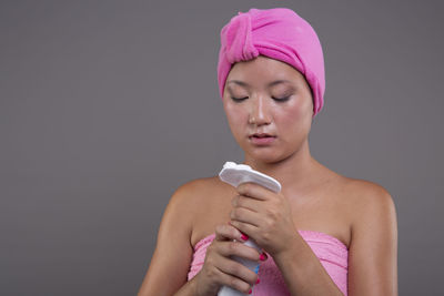 Portrait of young woman wearing mask against blue background