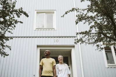 Smiling couple in front of house