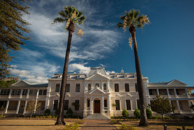 Palm trees by building against sky