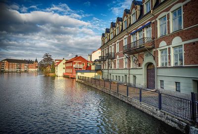 View of canal in city against sky