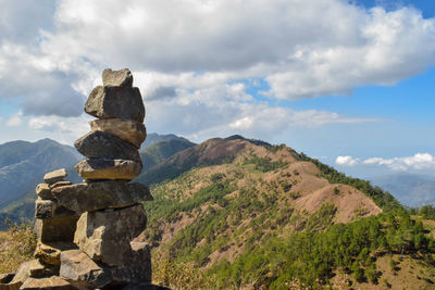 Stack of rocks on landscape against sky