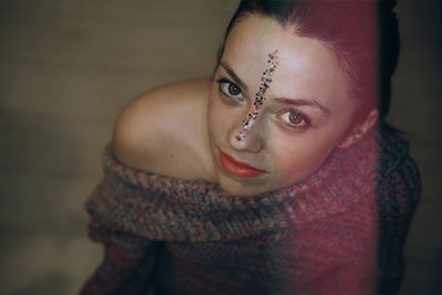 High angle portrait of young woman with glitter on face