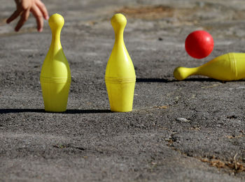 Close-up of yellow bowling pins on road