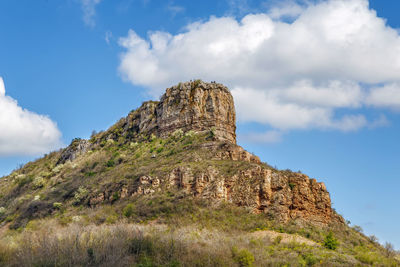 Low angle view of rock formation on mountain against sky