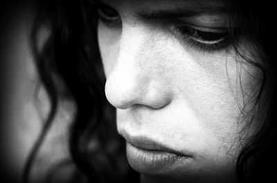 Close-up portrait of young woman against black background