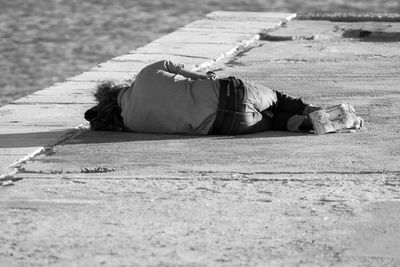 Woman lying down on sidewalk