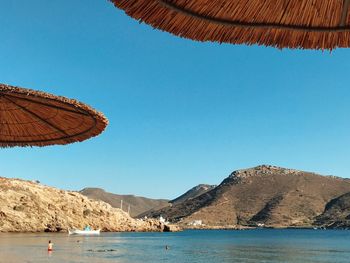 Low angle view of beach against clear blue sky