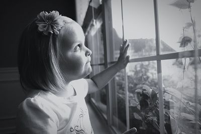 Close-up of girl looking through window