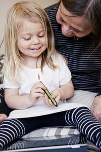 Grandmother and granddaughter drawing on digital tablet