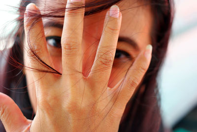 Portrait of woman covering face with hand