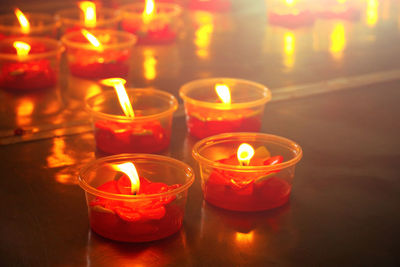 Close-up of lit tea light candles in temple