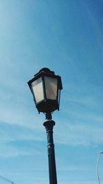 Low angle view of street light against blue sky