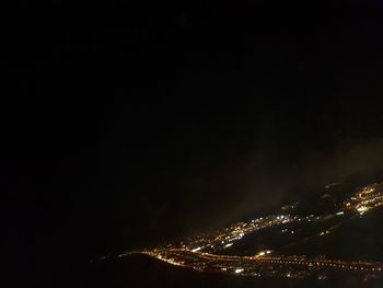 Low angle view of illuminated cityscape against sky at night