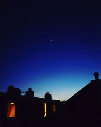 Silhouette of city against sky at night