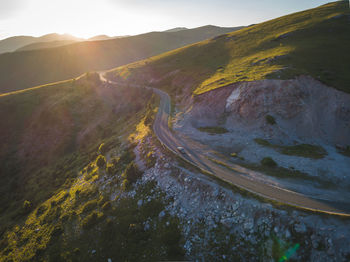 Scenic view of road by mountains against sky