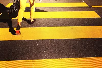 Low section of man walking on road