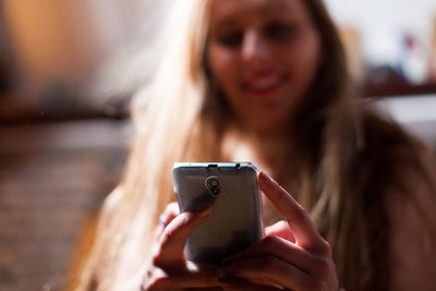 Close-up of woman using mobile phone at home