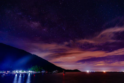 Scenic view of illuminated mountains against sky at night