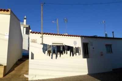 Clothes drying on building against clear blue sky