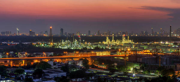 High angle view of illuminated buildings against sky at sunset oil refinery