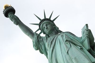 Low angle view of historic statue of liberty against sky