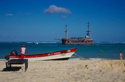 Boat moored on beach against sky