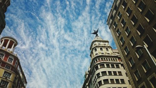 High section of buildings against clouds