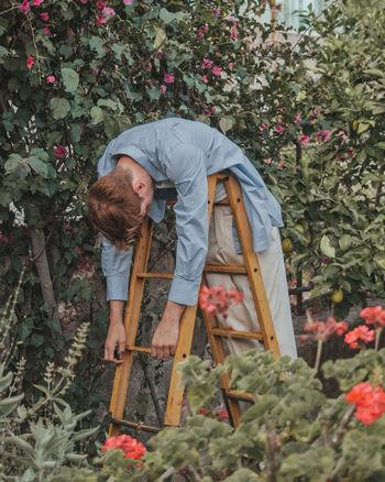 Rear view of person standing by flower plants