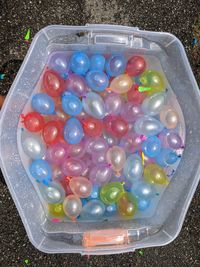 High angle view of multi colored balls in container