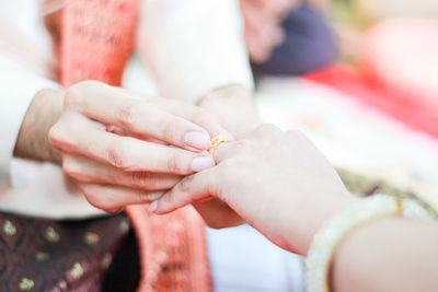 Midsection of couple holding hands