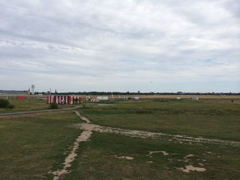 Scenic view of grassy field against cloudy sky