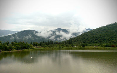Scenic view of lake and mountains against sky