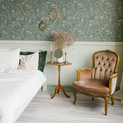The interior of a neoclassical bedroom. a bed with pillows and a classic armchair near the bedside