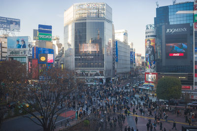 Crowd in city against sky