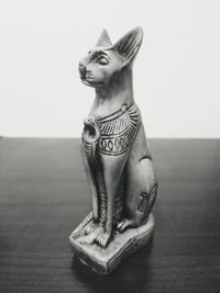 Female sculpture on table against gray background